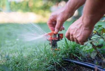 hands adjusting a Sprinkler