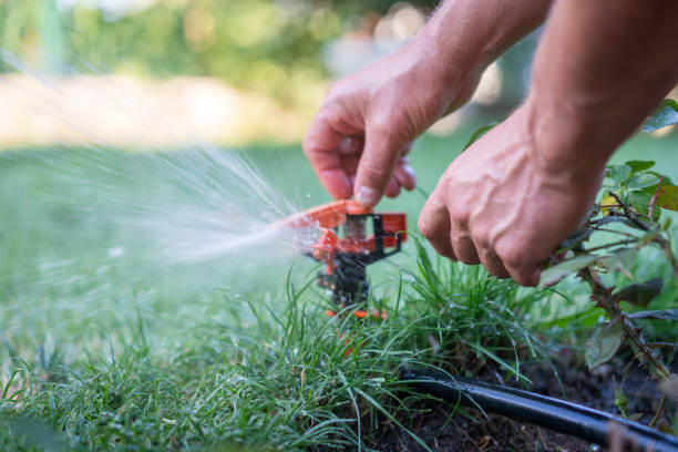hands adjusting a Sprinkler