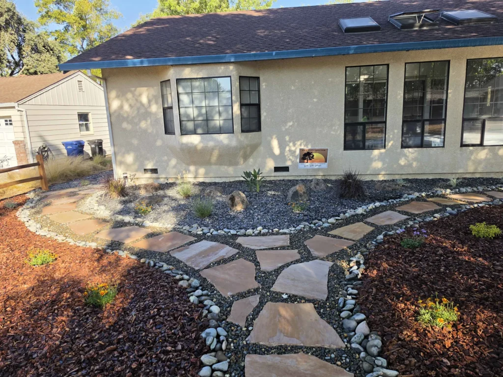 Branching flagstone paths bordered by gravel, mulch, boulders and low plantings.